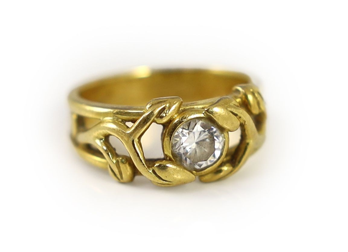 A modern pierced 18ct gold and solitaire diamond set band